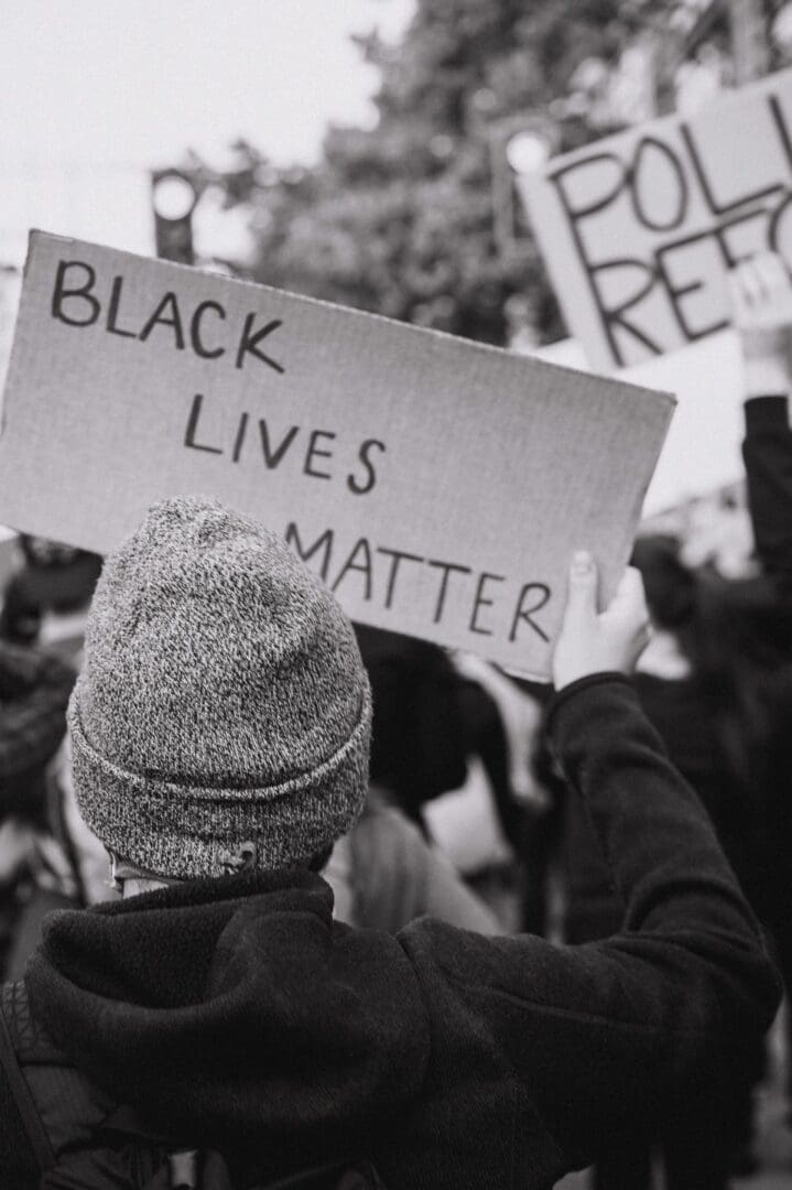 A person holding up a sign that says black lives matter.