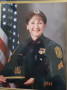 A woman in uniform smiling for the camera.